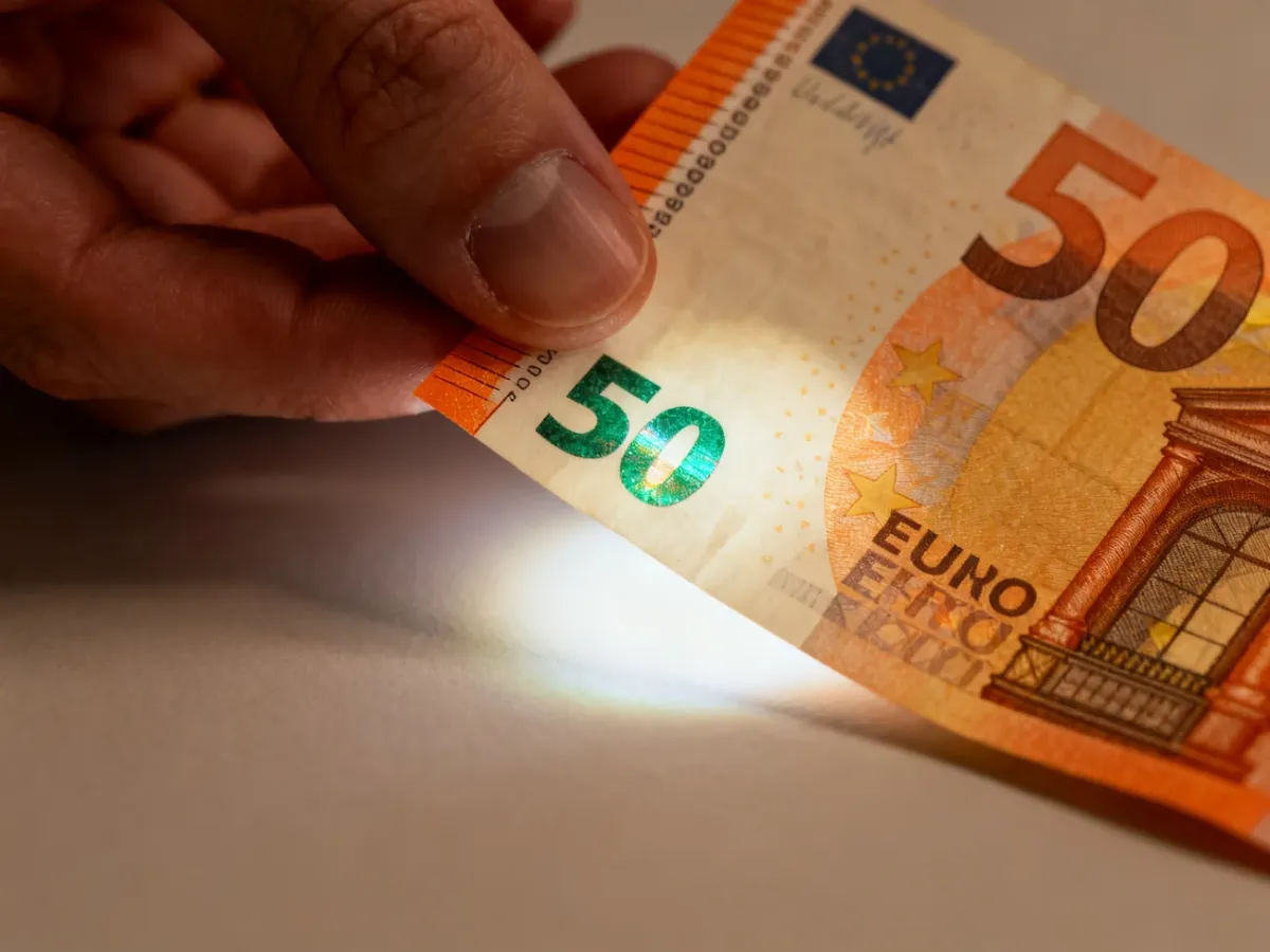 Sprawdzanie banknotu 50 euro przez przechylanie go pod światłem