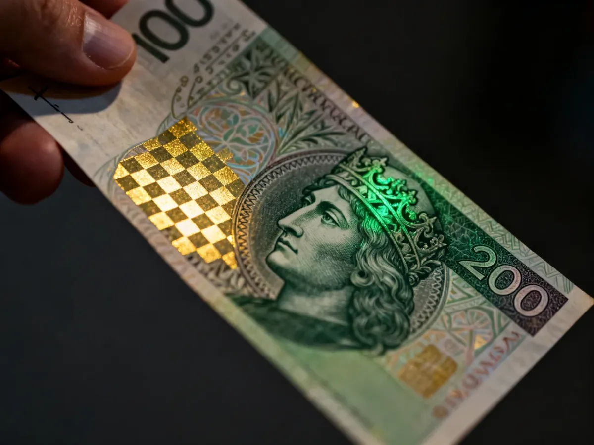 Banknot 200 zł przechylany w celu sprawdzenia zmiany koloru zabezpieczenia optycznego